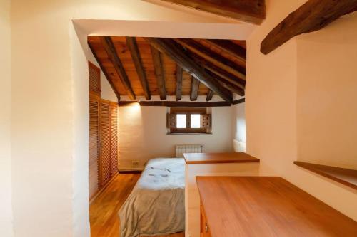 a bedroom with a bed in a room with wooden ceilings at Casa Rural Taller del Nogal 