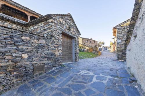 an alley with a stone building with a garage at Casa Rural Taller del Nogal 