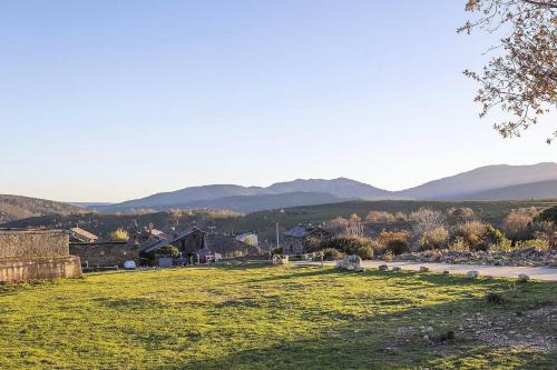 a field of grass with mountains in the background at Casa Rural Taller del Nogal 