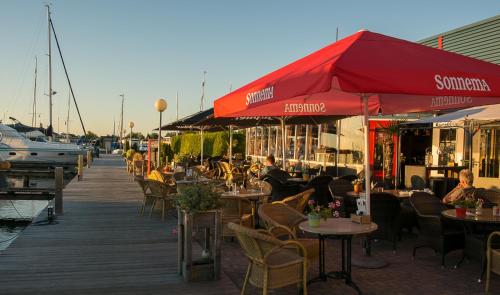 a wooden boardwalk with tables and chairs on a marina at Vakantiehuis Lemmer aan het water in Lemmer