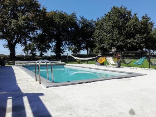 une piscine avec un toboggan et une aire de jeux dans l'établissement Longère Golfe du Morbihan avec piscine extérieure, à Plescop