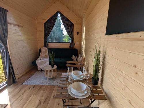 Cette chambre comprend une table, un canapé et une fenêtre. dans l'établissement La Vue en Rose by Tiny Away, à Sénaillac-Latronquière