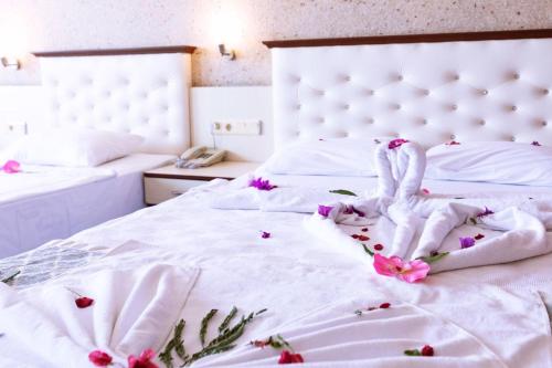 two swans are sitting on a bed with flowers at Mysea Hotels Incekum - All Inclusive in Avsallar