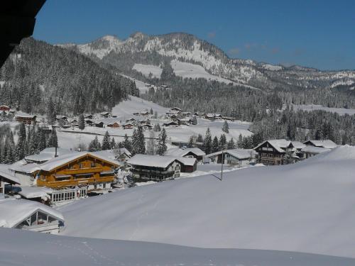 a town covered in snow with mountains in the background at Denninger's Ferienhäusle in Riezlern