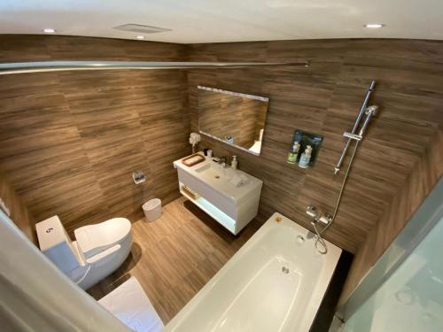 a bathroom with a toilet and a sink and a tub at GOGO Hotel 市政館 in Taichung