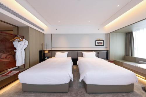 a hotel room with two beds and a couch at Ramada by Wyndham Foshan Danzao in Huadu