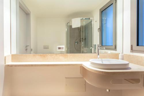 a bathroom with a sink and a large mirror at Casa Katy Sul Porto Di Stintino in Stintino