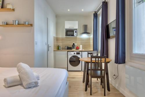 une chambre avec un lit et une table et une cuisine dans l'établissement Anne studio tout équipé à proximité de la gare et du centre-ville, à Rouen