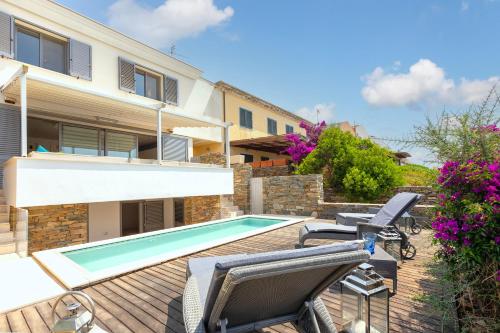 a house with a swimming pool and some chairs at Casa Katy Sul Porto Di Stintino in Stintino