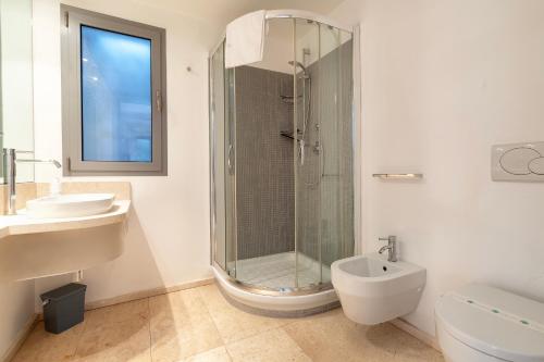 a bathroom with a shower and a sink and a toilet at Casa Katy Sul Porto Di Stintino in Stintino