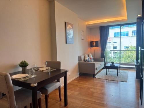 a living room with a table and a living room with a couch at Central Living Ploenchit in Bang Kapi