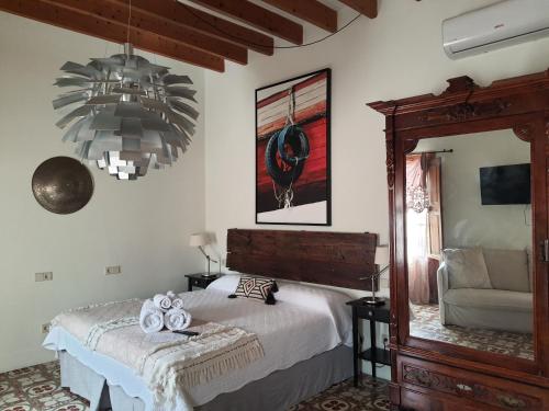 a bedroom with a bed and a chandelier at Flor de Mandarina in Sa Pobla