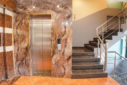 a elevator in a building with a large rock wall at FabHotel Brij Residency - hoshangabad , Near barkatullah university in Naiāpura