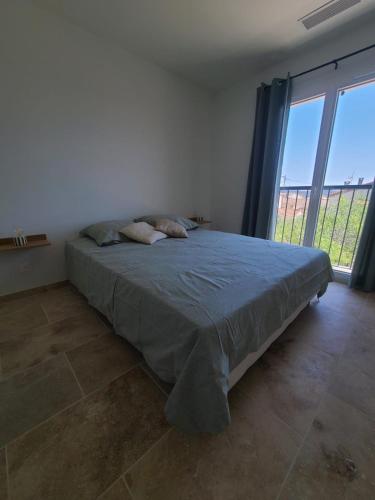 une chambre avec un lit et une grande fenêtre dans l'établissement Villa neuve avec piscine et vue panoramique, à La Fare-les-Oliviers