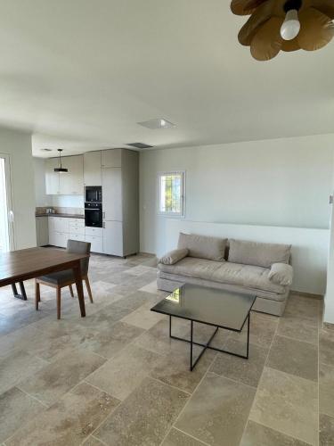 un salon avec un canapé et une table dans l'établissement Villa neuve avec piscine et vue panoramique, à La Fare-les-Oliviers