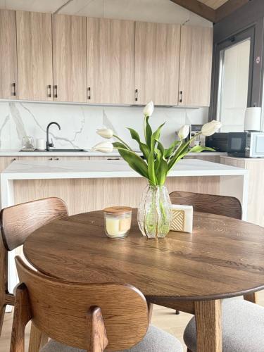 a kitchen with a wooden table with a vase with flowers at REY Chalet in Vatra Dornei