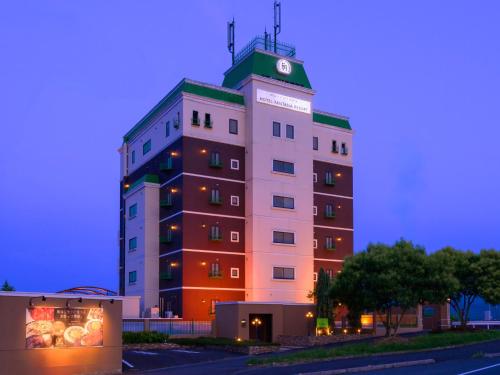 a building with a clock on the top of it at ホテルファンタジアリゾート 松山 -Adult Only- in Matsuyama
