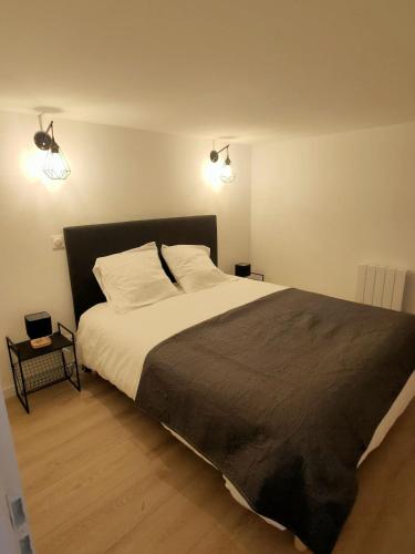 La Chapelle-de-GuinchayにあるSaint-Amour domaine de la vigneのベッドルーム1室(大型ベッド1台、照明2つ付)