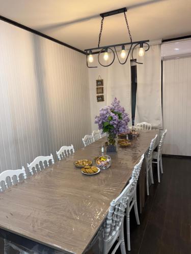 a large long table with white chairs and flowers at Riverside House Quba in Quba