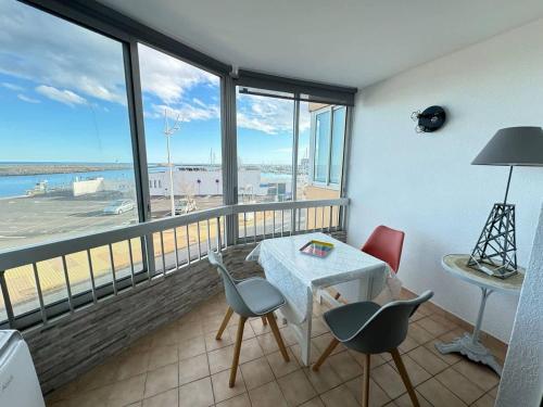 une chambre avec une table et des chaises et une vue sur l'aéroport dans l'établissement 19 Cocon Familial Vue Mer, à Valras-Plage