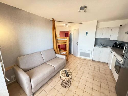 un salon avec un canapé et une cuisine dans l'établissement 19 Cocon Familial Vue Mer, à Valras-Plage