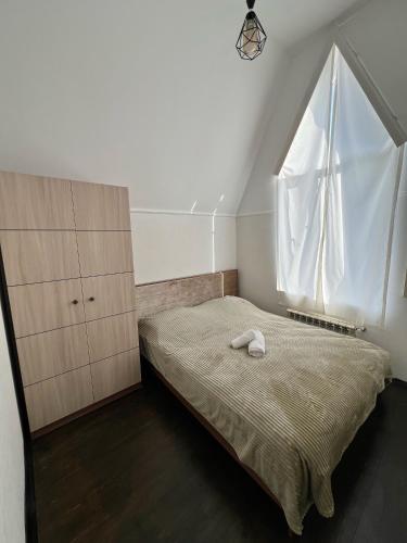 a small bedroom with a bed and a window at Riverside House Quba in Quba