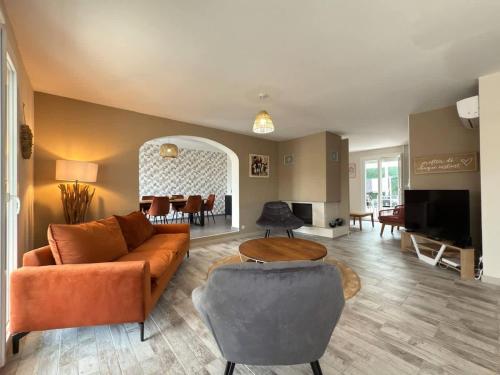 a living room with a couch and a table at Oasis privee a Vendres piscine et confort moderne in Vendres