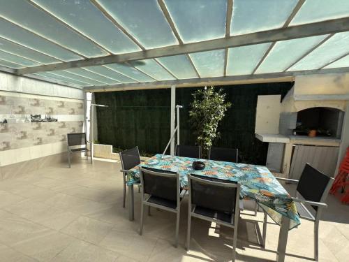 une salle à manger avec une table et des chaises dans l'établissement Oasis privee a Vendres piscine et confort moderne, à Vendres