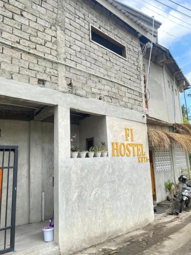 a building with a hostel sign on the side of it at Fi Hostel Kuta Lombok in Kuta Lombok