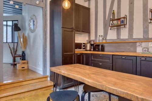 - une cuisine avec un comptoir en bois et une table dans l'établissement Ana charmant 2 pièces au cœur du centre historique de Rouen, à Rouen