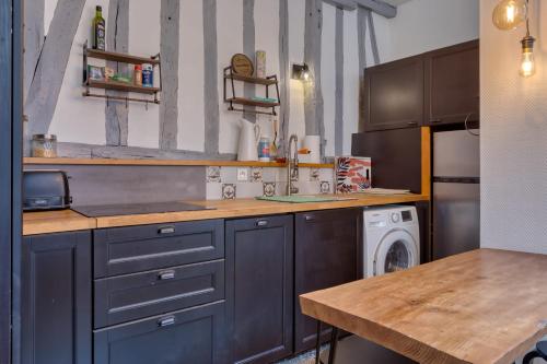 - une cuisine avec des placards bleus et un lave-linge/sèche-linge dans l'établissement Ana charmant 2 pièces au cœur du centre historique de Rouen, à Rouen