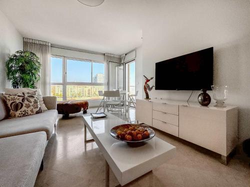 a living room with a television and a bowl of fruit on a table at Breeze Suite at The Island in Herzliya B