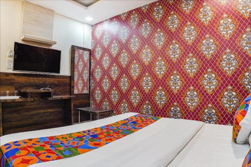 a bedroom with a bed and a red wall at FabHotel Brij Residency - hoshangabad , Near barkatullah university in Naiāpura