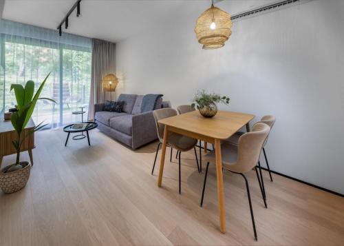 a living room with a table and a couch at Apartamenty na Półwyspie Wydma&Las in Jastarnia