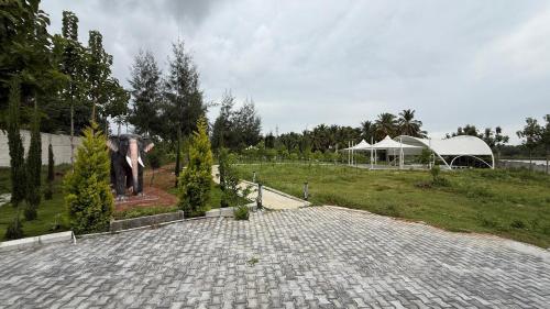 a horse is standing in a field with a building at Encanto Farmstay in Mysore
