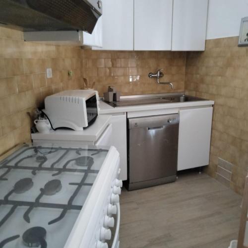 a kitchen with a sink and a printer on a stove at Perlablu' Home in Anzio