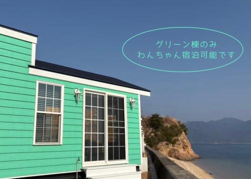 a green house next to a body of water at 宮島リゾート Hauol'i in Hatsukaichi