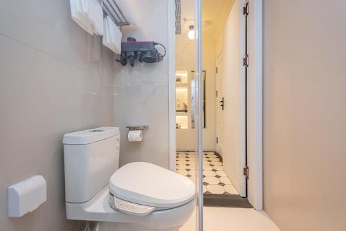 a bathroom with a toilet and a walk in shower at TUIWA Garden Holiday Villa in Qingdao