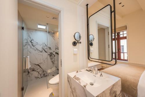 a bathroom with a sink and a mirror at TUIWA Garden Holiday Villa in Qingdao