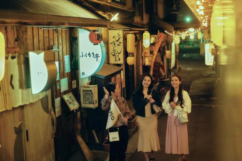 two women are standing in front of a shop at OMO7 Asahikawa by Hoshino Resorts in Asahikawa