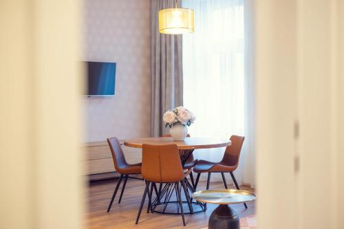 a dining room table with chairs and a vase with flowers at LeonArt Living 21 in Graz