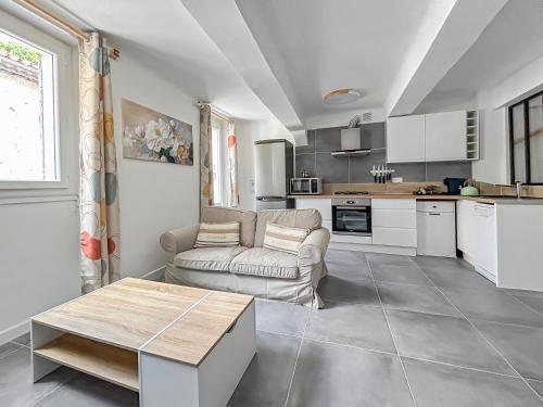 a living room with a couch and a table at Appartement cosy et lumineux au cœur de Cogolin in Cogolin