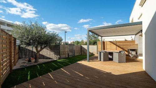 une cour avec une terrasse en bois et une clôture dans l'établissement Valras-Loc La Dune Villa Familiale, Mer et Piscine, à Sérignan