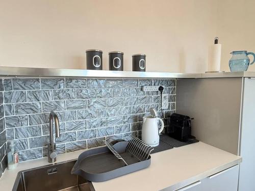 une cuisine avec un évier et un plan de travail dans l'établissement Valras-Loc Sablon - T4 Front de Mer avec Balcon, à Valras-Plage