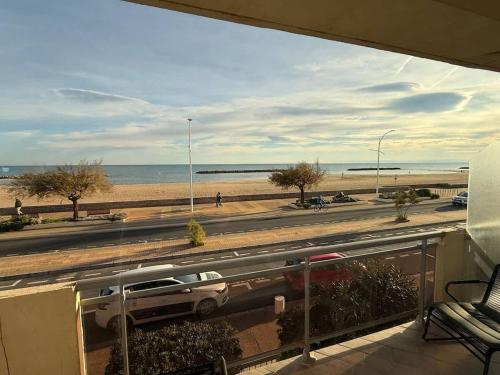 - un balcon avec vue sur la plage et une voiture dans l'établissement Valras-Loc Sablon - T4 Front de Mer avec Balcon, à Valras-Plage