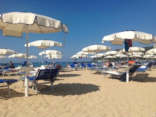 a group of chairs and umbrellas on a beach at Perlablu' Home in Anzio
