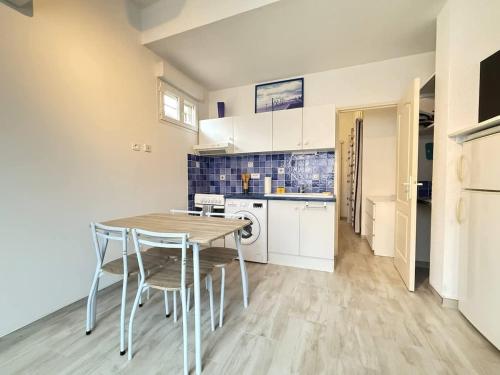 une cuisine et une salle à manger avec une table et des chaises dans l'établissement Appartement en Rez-de-Chaussee a Deux Pas de la Plage, à Valras-Plage