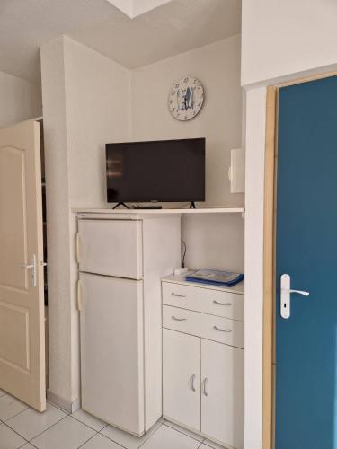 Il comprend une cuisine équipée d'un réfrigérateur et une télévision murale. dans l'établissement Appartement en Rez-de-Chaussee a Deux Pas de la Plage, à Valras-Plage