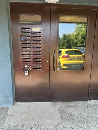 a brown door with a reflection of a yellow car at Апартамент Миели in Sofia