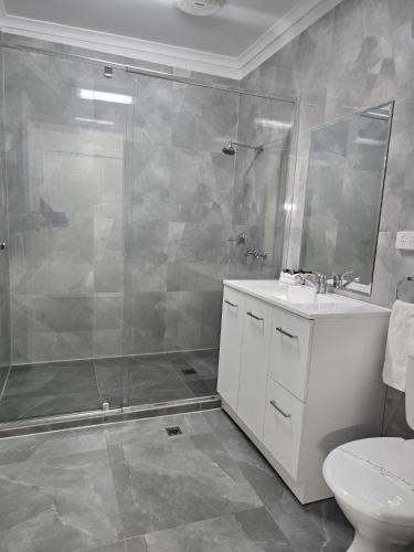 a bathroom with a shower and a sink and a toilet at KooWeeRup Motel in Koo-Wee-Rup